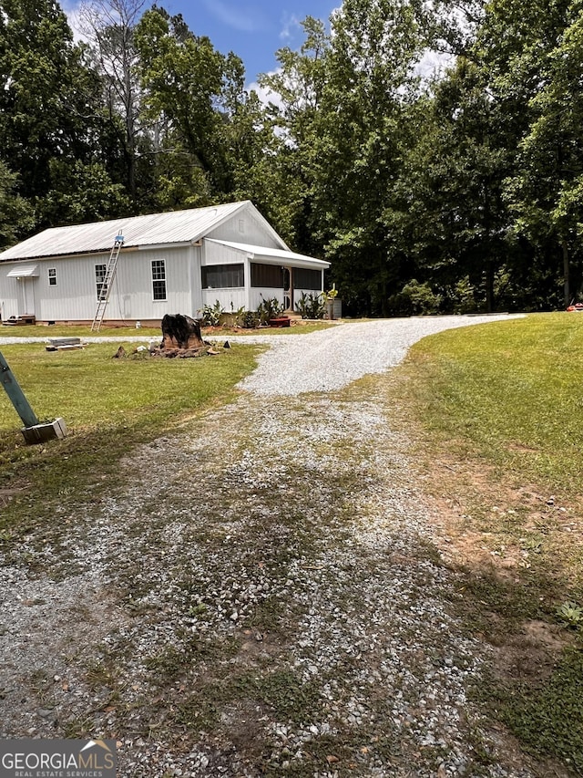 44 Freeman, Heflin, AL 36264 - view of property exterior with a lawn, a metal roof, and driveway