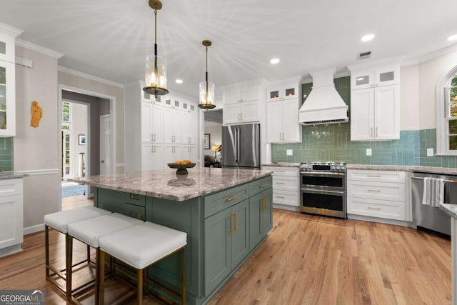 220 Webley Ln, Alpharetta, GA 30022 - kitchen with stainless steel appliances, premium range hood, white cabinets, plenty of natural light, and ornamental molding