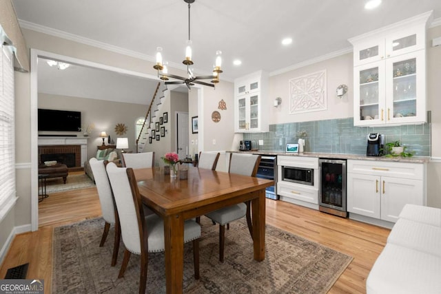 220 Webley Ln, Alpharetta, GA 30022 - dining space with beverage cooler, stairway, a chandelier, bar, and crown molding