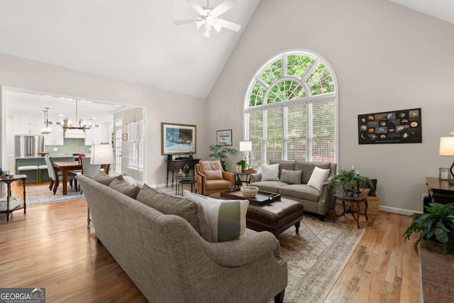 220 Webley Ln, Alpharetta, GA 30022 - living area with high vaulted ceiling, a ceiling fan, light wood-style flooring, a chandelier, and baseboards