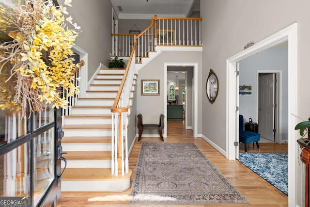 220 Webley Ln, Alpharetta, GA 30022 - foyer featuring a towering ceiling, stairway, wood finished floors, baseboards, and ornamental molding