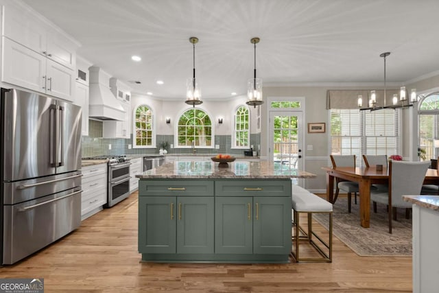 220 Webley Ln, Alpharetta, GA 30022 - kitchen featuring appliances with stainless steel finishes, green cabinetry, custom exhaust hood, white cabinets, and a chandelier