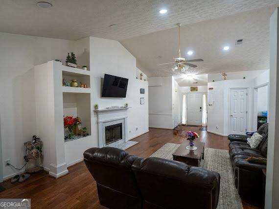 2840 General Lee Way, Buford, GA 30519 - living area with wood finished floors, a ceiling fan, a fireplace with flush hearth, recessed lighting, and vaulted ceiling