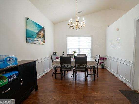 2840 General Lee Way, Buford, GA 30519 - dining space featuring vaulted ceiling, a chandelier, a decorative wall, dark wood finished floors, and wainscoting