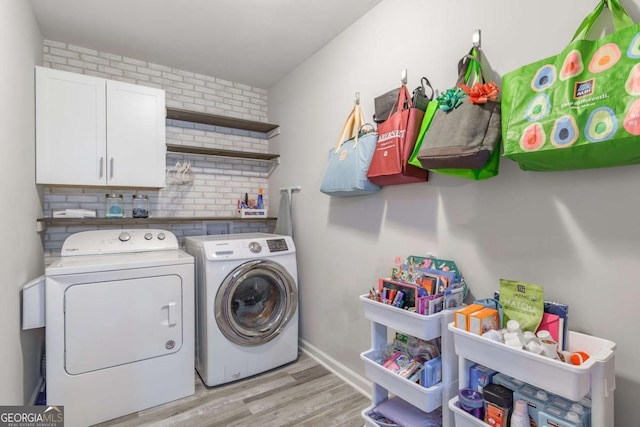 2038 Summertown Dr, Norcross, GA 30071 - laundry room with separate washer and dryer, light wood-style flooring, cabinet space, baseboards, and brick wall