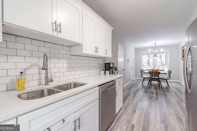 2038 Summertown Dr, Norcross, GA 30071 - kitchen featuring stainless steel appliances, a sink, backsplash, white cabinetry, and light wood-type flooring