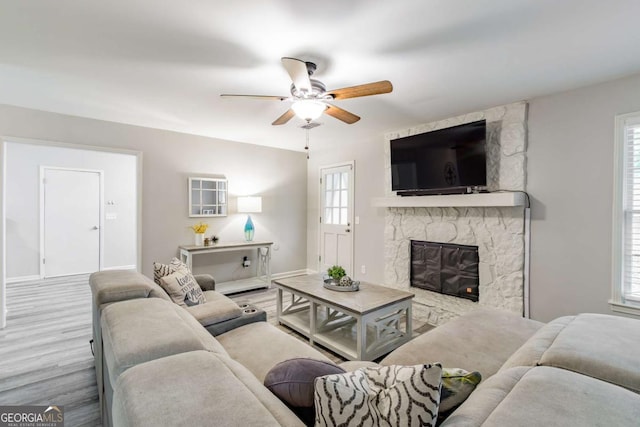 2038 Summertown Dr, Norcross, GA 30071 - living room featuring a ceiling fan, a stone fireplace, wood finished floors, and plenty of natural light
