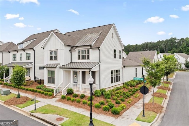 993 Harvest Park Ln, Suwanee, GA 30024 - view of front facade with covered porch, a standing seam roof, board and batten siding, a residential view, and a metal roof