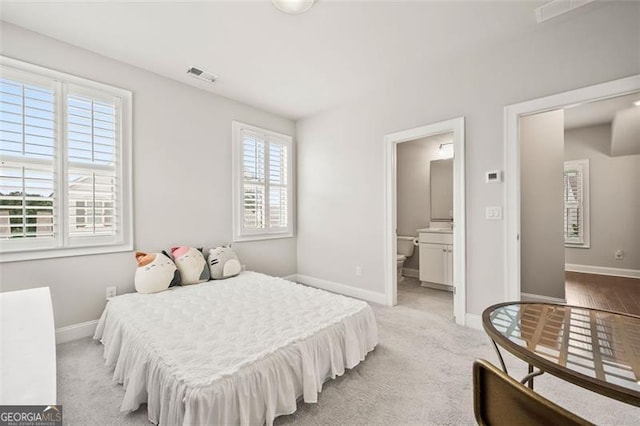993 Harvest Park Ln, Suwanee, GA 30024 - bedroom with multiple windows, connected bathroom, and light colored carpet