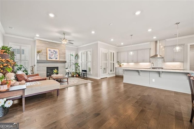 993 Harvest Park Ln, Suwanee, GA 30024 - living room featuring a ceiling fan, recessed lighting, dark wood-style flooring, crown molding, and a tile fireplace