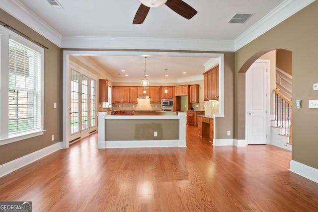 12194 Limeridge Ct, Alpharetta, GA 30004 - kitchen featuring arched walkways, light wood-type flooring, ceiling fan, tasteful backsplash, and brown cabinetry