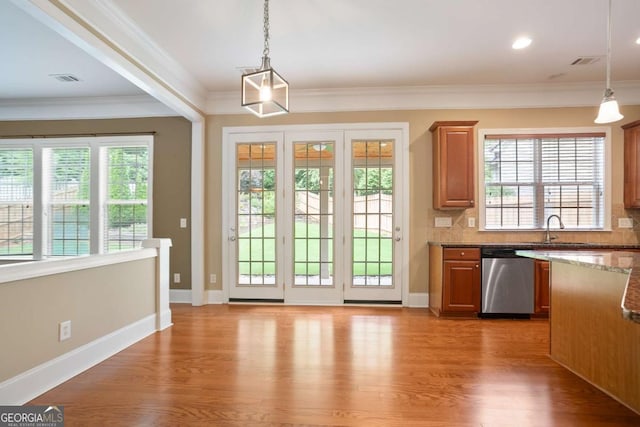 12194 Limeridge Ct, Alpharetta, GA 30004 - kitchen with stainless steel dishwasher, healthy amount of natural light, decorative light fixtures, wood finished floors, and crown molding