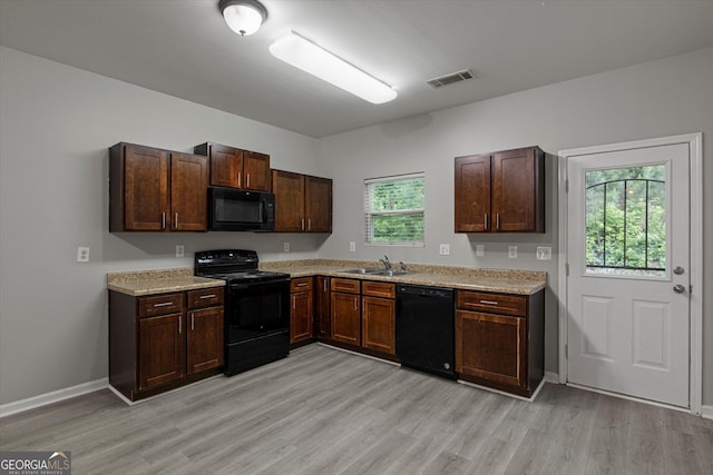 2137 Chadwick Rd SW, Atlanta, GA 30331 - kitchen featuring black appliances, light countertops, light wood-style flooring, a sink, and baseboards
