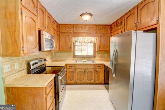 402 Princeton Way, Lawrenceville, GA 30044 - kitchen featuring appliances with stainless steel finishes, light countertops, tasteful backsplash, brown cabinetry, and a textured ceiling