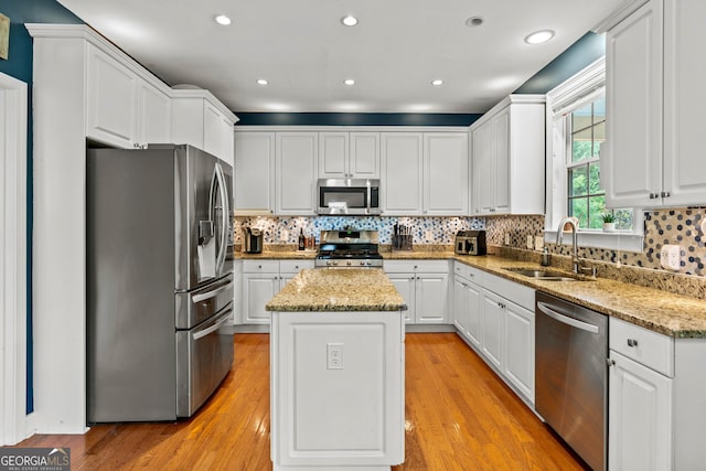 638 Glen Valley Way, Dacula, GA 30019 - kitchen with appliances with stainless steel finishes, a center island, white cabinets, light wood-type flooring, and tasteful backsplash