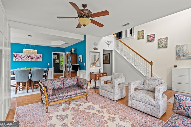 638 Glen Valley Way, Dacula, GA 30019 - living area with stairs, a ceiling fan, wood finished floors, and a tray ceiling
