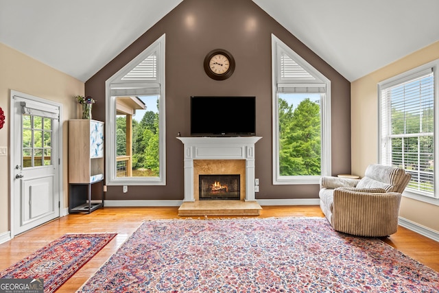 638 Glen Valley Way, Dacula, GA 30019 - living room with vaulted ceiling, plenty of natural light, wood finished floors, and a warm lit fireplace