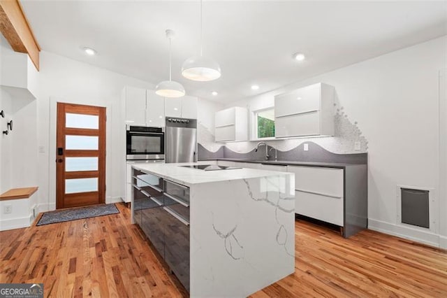 1492 Sagewood Cir, Stone Mountain, GA 30083 - kitchen with modern cabinets, fridge, white cabinetry, stainless steel double oven, and hanging light fixtures