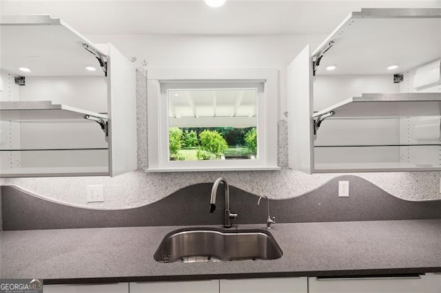1492 Sagewood Cir, Stone Mountain, GA 30083 - kitchen featuring dark countertops, decorative backsplash, and white cabinets