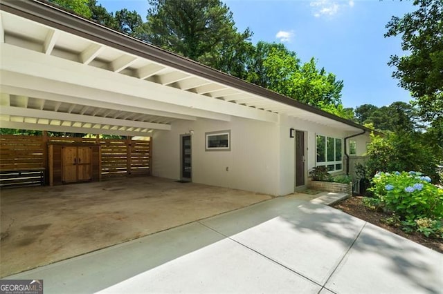 1492 Sagewood Cir, Stone Mountain, GA 30083 - view of side of home featuring driveway, stucco siding, and a carport