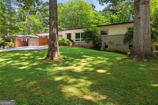 1492 Sagewood Cir, Stone Mountain, GA 30083 - ranch-style home with concrete driveway, brick siding, and a front yard