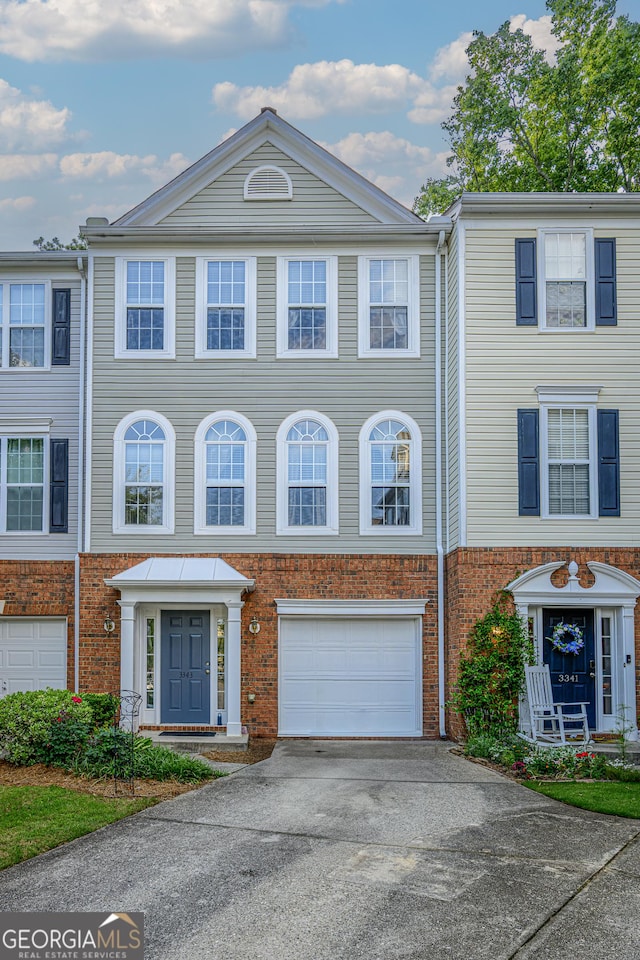 3343 Lathenview Ct, Milton, GA 30004 - townhome / multi-family property featuring a garage, driveway, and brick siding