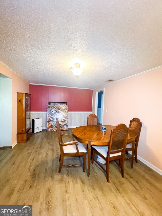 1191 Zoar Rd, Baxley, GA 31513 - dining space featuring light wood-style floors, a textured ceiling, ornamental molding, and baseboards
