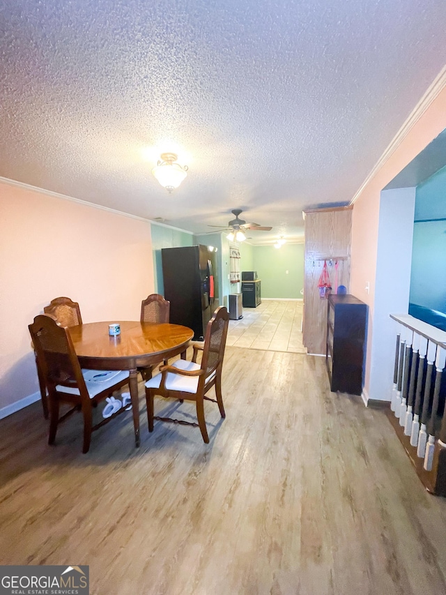 1191 Zoar Rd, Baxley, GA 31513 - dining space featuring light wood-style floors, a textured ceiling, a ceiling fan, ornamental molding, and baseboards