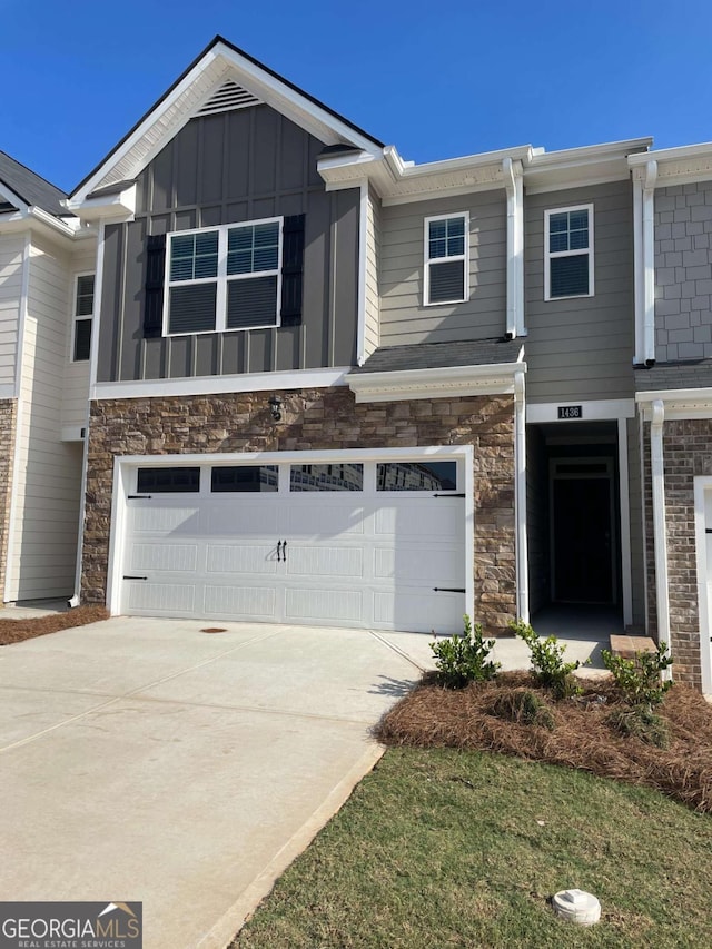 1404 Gray Branch Dr, Lawrenceville, GA 30045 - view of front of property featuring an attached garage, board and batten siding, concrete driveway, and stone siding