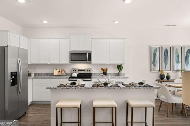 1404 Gray Branch Dr, Lawrenceville, GA 30045 - kitchen with appliances with stainless steel finishes, a kitchen breakfast bar, white cabinets, light stone counters, and recessed lighting