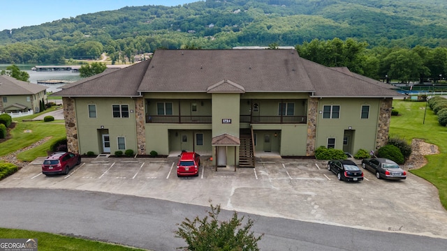 1724 Watercrest Way # G, Young Harris, GA 30582 - view of front facade featuring stucco siding, uncovered parking, a forest view, stone siding, and roof with shingles