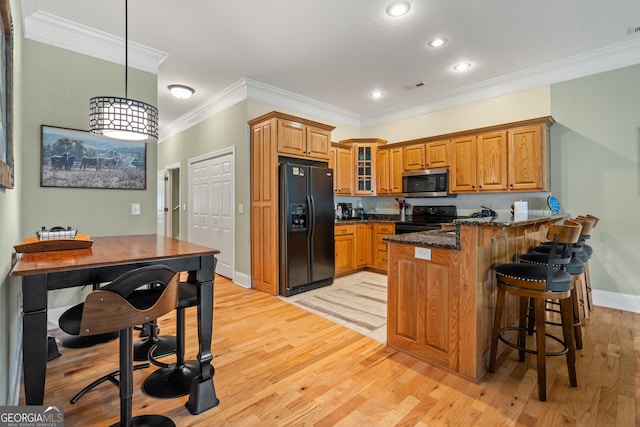 1724 Watercrest Way # G, Young Harris, GA 30582 - kitchen with black appliances, a peninsula, brown cabinetry, crown molding, and light wood-style flooring