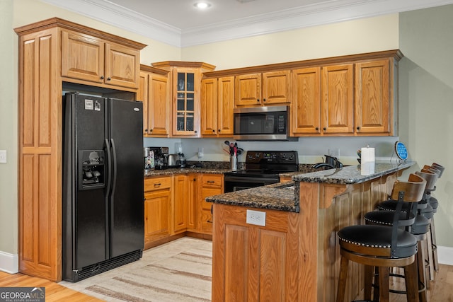 1724 Watercrest Way # G, Young Harris, GA 30582 - kitchen with black appliances, a peninsula, dark stone countertops, crown molding, and a breakfast bar