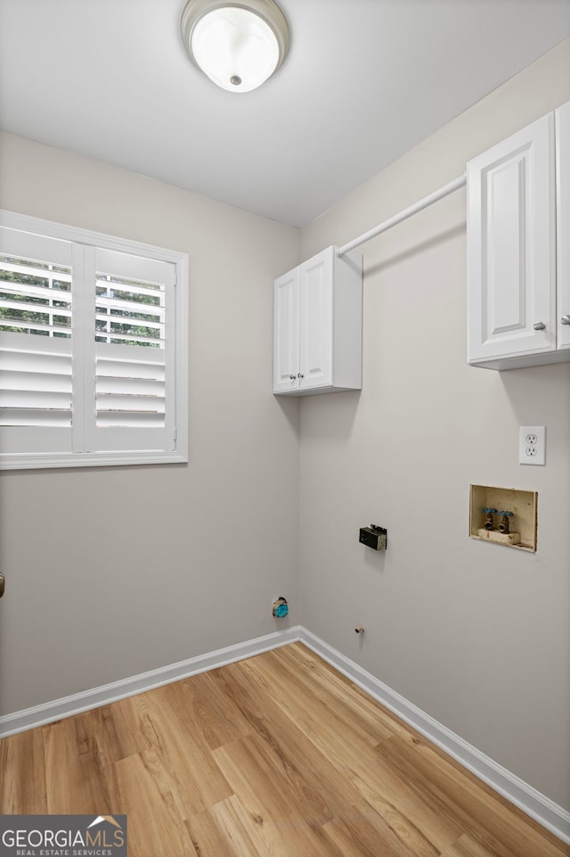 105 Paces Landing Trl, Newnan, GA 30263 - laundry area featuring light wood-style floors, baseboards, washer hookup, and cabinet space