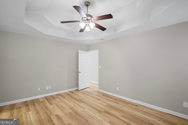 105 Paces Landing Trl, Newnan, GA 30263 - empty room featuring a tray ceiling, light wood-style floors, ceiling fan, and baseboards