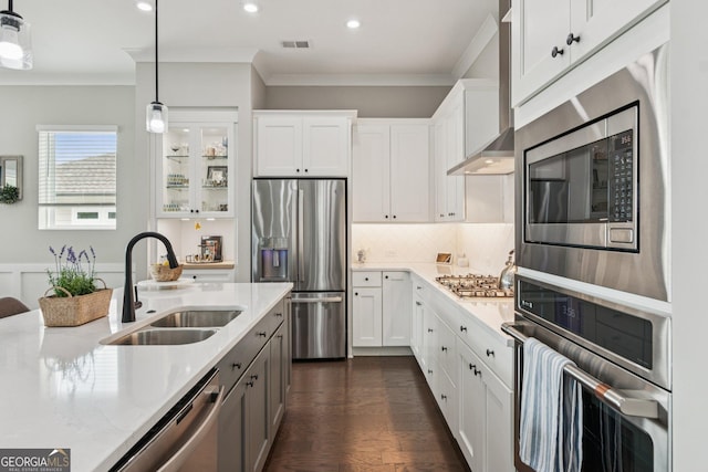 6937 River Rock Dr, Flowery Branch, GA 30542 - kitchen with stainless steel appliances, crown molding, wall chimney exhaust hood, white cabinetry, and pendant lighting