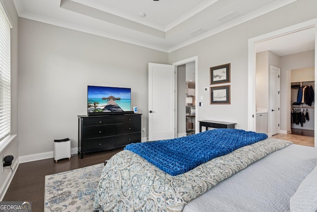 6937 River Rock Dr, Flowery Branch, GA 30542 - bedroom with wood finished floors, a walk in closet, a tray ceiling, ornamental molding, and a closet