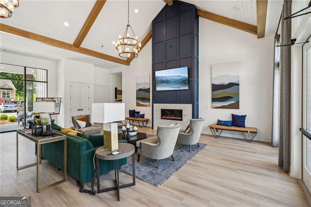 6937 River Rock Dr, Flowery Branch, GA 30542 - living room featuring high vaulted ceiling, a chandelier, beamed ceiling, light wood-style flooring, and a fireplace