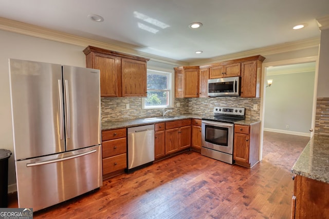 1177 Castle Way, Norcross, GA 30093 - kitchen with stainless steel appliances, ornamental molding, brown cabinets, dark wood-style flooring, and a sink