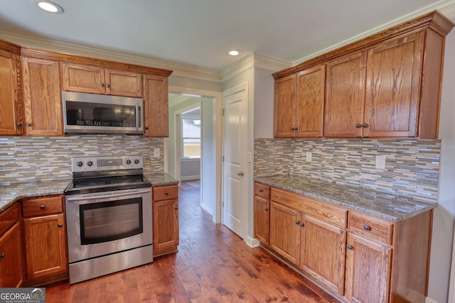 1177 Castle Way, Norcross, GA 30093 - kitchen featuring appliances with stainless steel finishes, ornamental molding, brown cabinets, stone counters, and recessed lighting