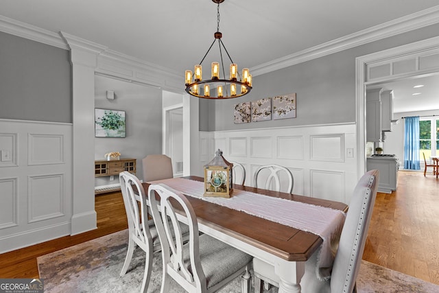 55 Jolie Ln, Sharpsburg, GA 30277 - dining area with ornamental molding, a chandelier, light wood-type flooring, wainscoting, and a decorative wall