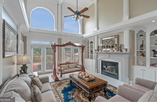 413 Canterbury Way, Jonesboro, GA 30236 - living room featuring a ceiling fan, built in features, a glass covered fireplace, a towering ceiling, and french doors