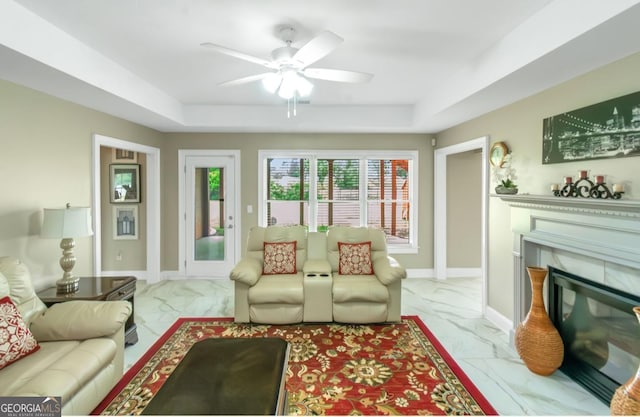 413 Canterbury Way, Jonesboro, GA 30236 - living area with marble look tiles, a ceiling fan, and a tray ceiling