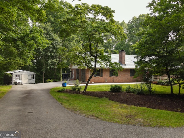 323 Mccartan Trl, Clarkesville, GA 30523 - single story home with a chimney, asphalt driveway, an outbuilding, brick siding, and metal roof