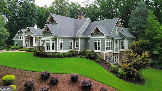 114 Trinity Hollow Dr, Canton, GA 30115 - craftsman-style house featuring a chimney, a front lawn, a shingled roof, and stone siding
