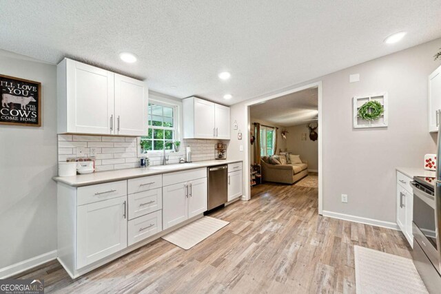 187 Angers Ct, Dahlonega, GA 30533 - kitchen featuring stainless steel appliances, a sink, tasteful backsplash, light countertops, and white cabinetry