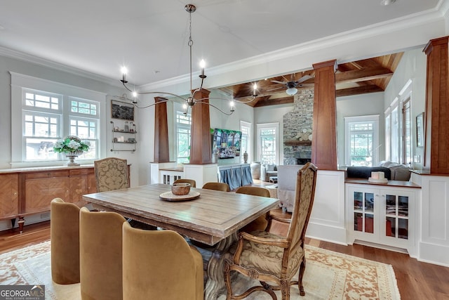 114 Trinity Hollow Dr, Canton, GA 30115 - dining space featuring plenty of natural light, wood finished floors, a stone fireplace, beam ceiling, and ornamental molding