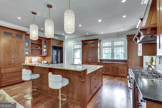114 Trinity Hollow Dr, Canton, GA 30115 - kitchen featuring paneled fridge, stainless steel gas stove, brown cabinetry, crown molding, and light wood-type flooring
