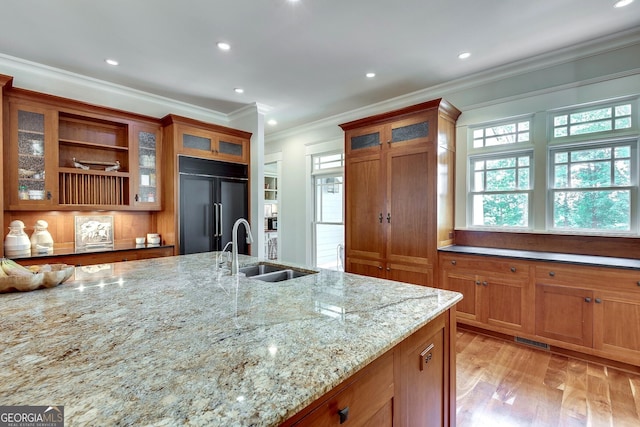 114 Trinity Hollow Dr, Canton, GA 30115 - kitchen featuring paneled fridge, a sink, brown cabinetry, light wood-type flooring, and ornamental molding