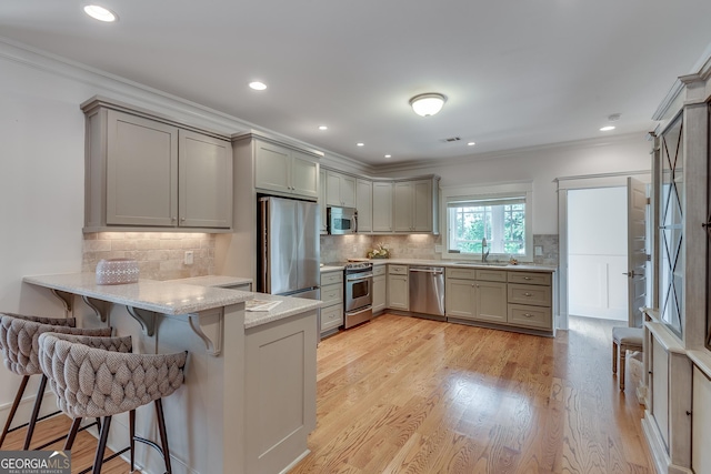 114 Trinity Hollow Dr, Canton, GA 30115 - kitchen with stainless steel appliances, a peninsula, ornamental molding, a kitchen breakfast bar, and a sink